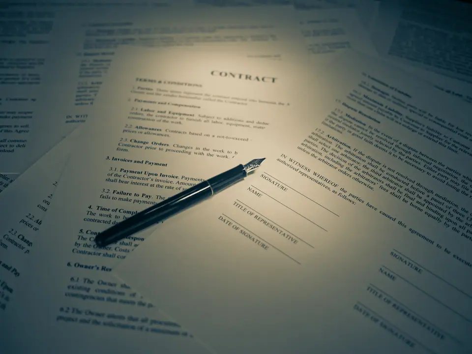Una persona firma un documento impreso con una lapicera, de cerca