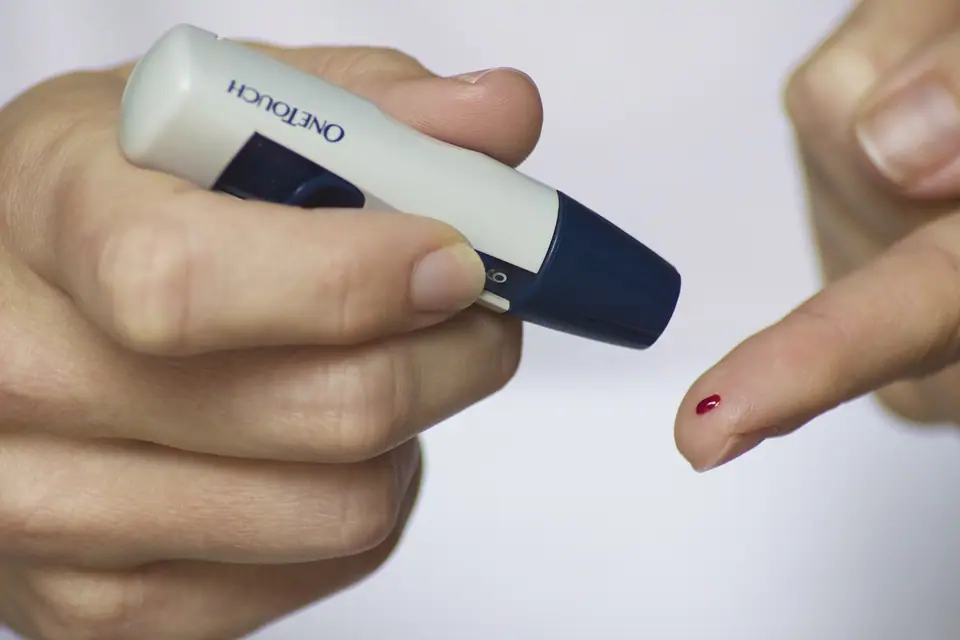 Medición de glucosa en sangre con punción en el dedo y un glucómetro