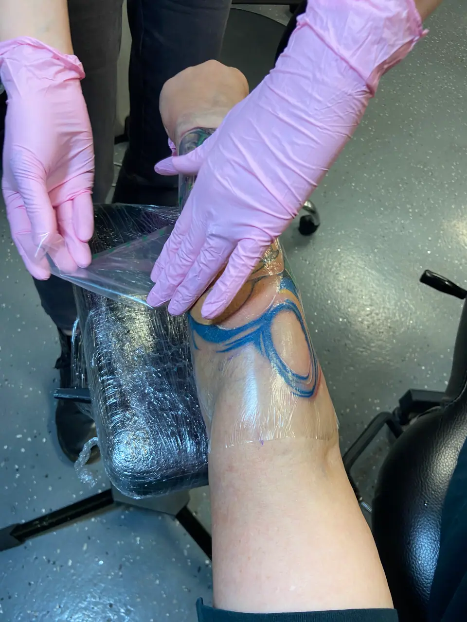 Colocando film transparente (segunda piel) sobre un tatuaje en la pierna, en las primeras etapas de curación