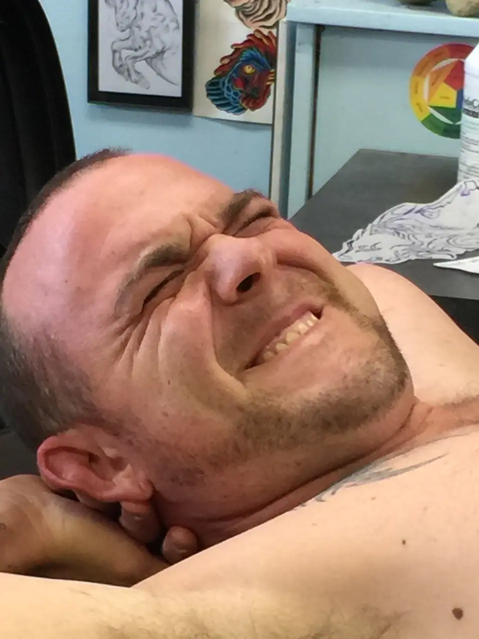 Persona haciendo un gesto de dolor durante una sesión de tatuaje
