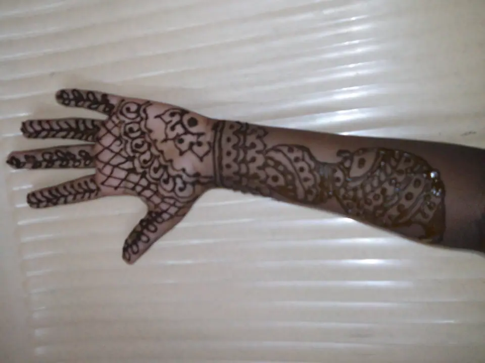 Diseño de henna recién aplicado secándose sobre la mano