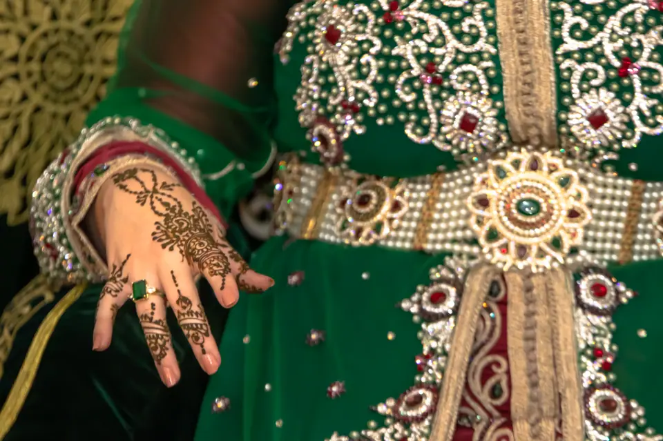 Henna aplicada sobre la mano junto a vestimenta tradicional