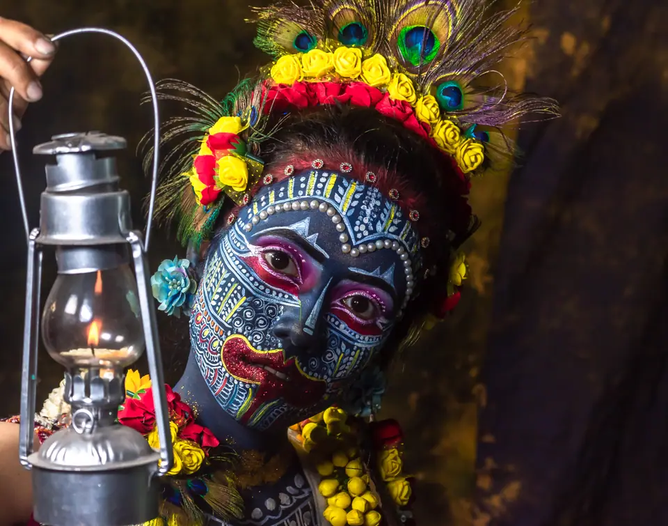 Maquillaje de cara y cuerpo con tocado floral y plumas de pavo real