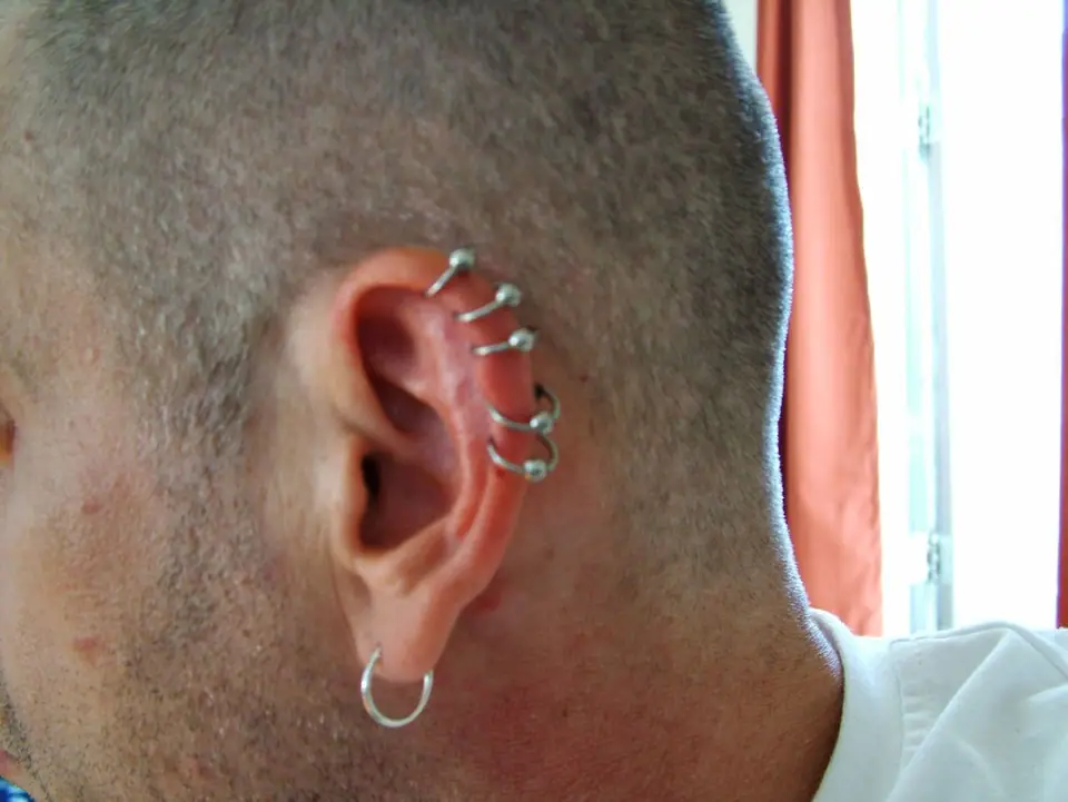 Oreja con varios piercings de cartílago, vista de perfil