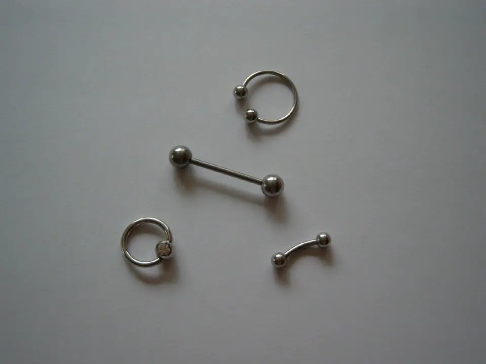 Variedad de joyería de piercing: argollas y barbells de distintos tamaños