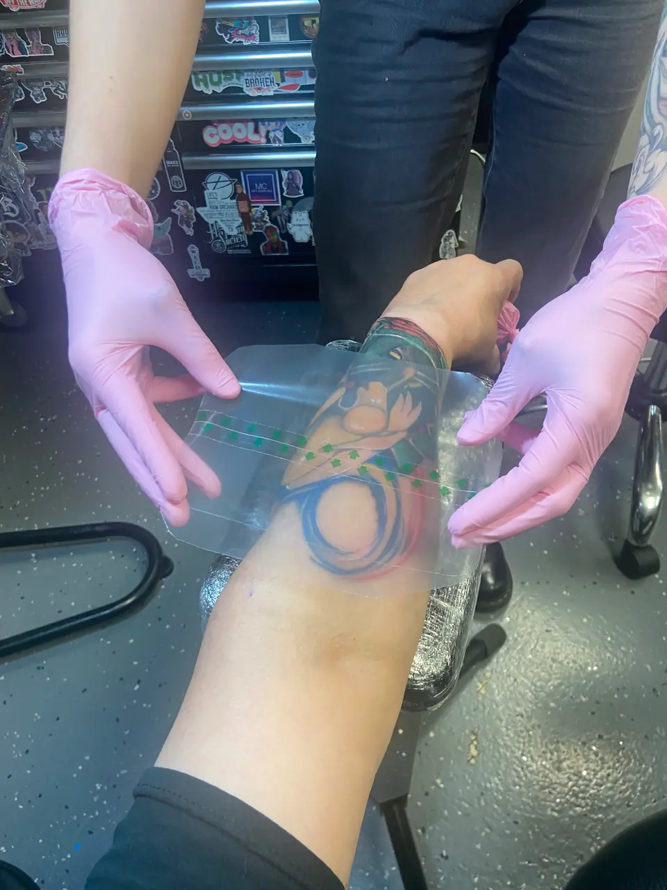 Colocación de film transparente sobre un tatuaje en el antebrazo en las primeras etapas de curación