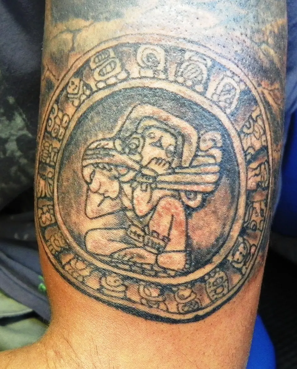 Tatuaje circular de la piedra del sol (calendario azteca) en el antebrazo