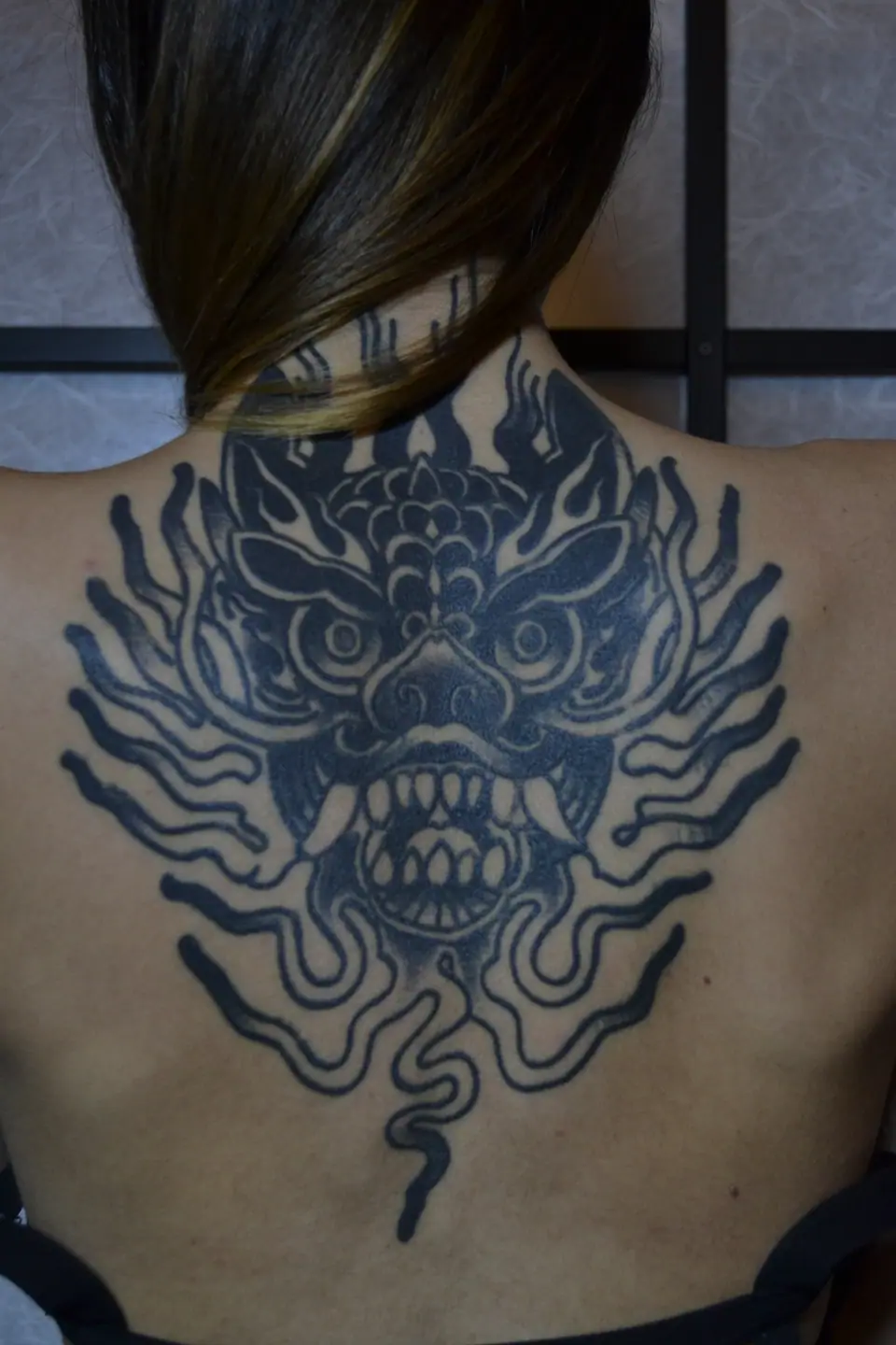 Tatuaje blackwork de un dragón en la espalda, ya cicatrizado