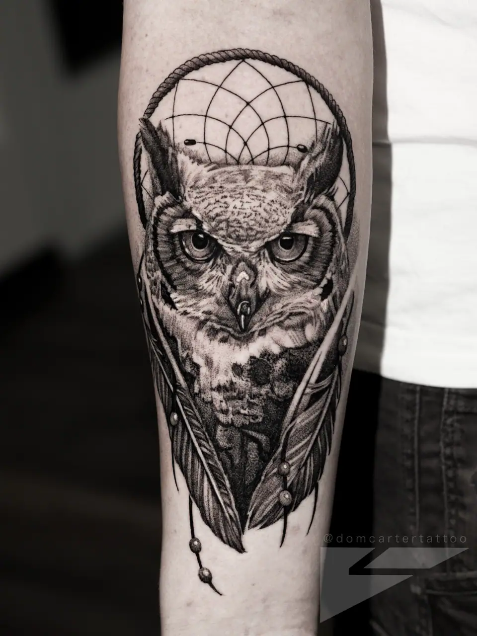 Tatuaje realista de un búho en el antebrazo