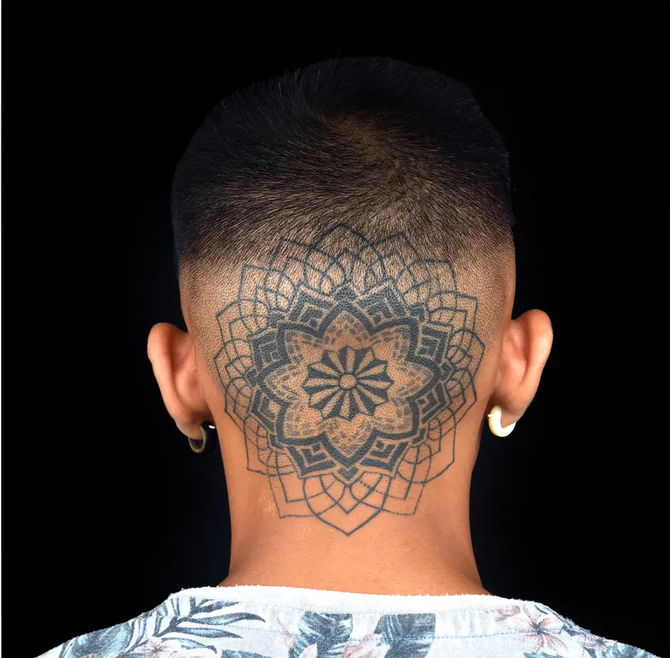 Tatuaje dotwork de mandala en la nuca y la cabeza rapada