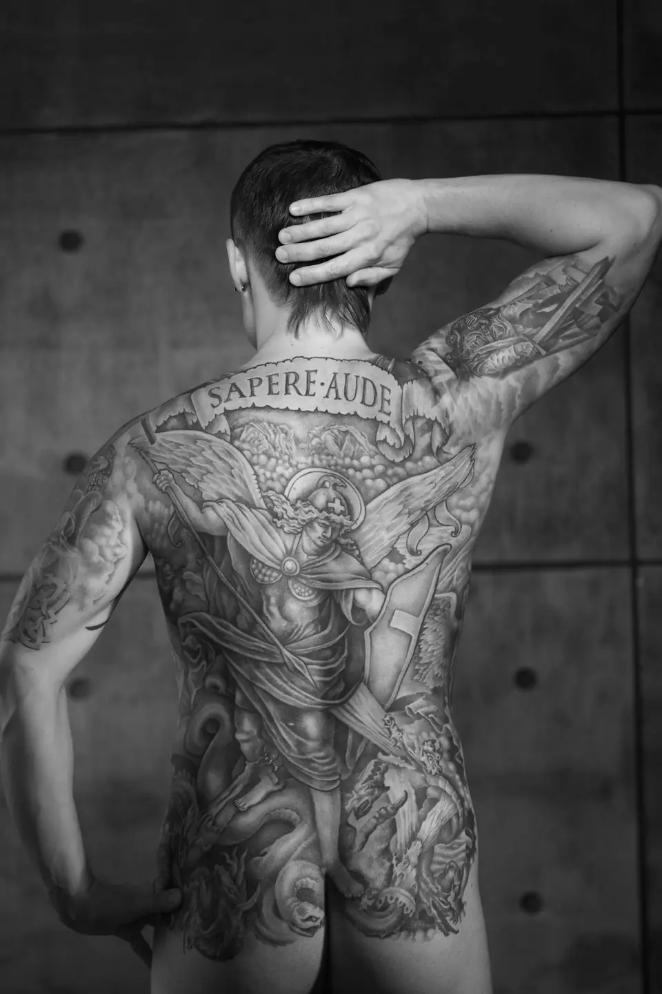 Hombre con tatuaje completo de espalda, foto en blanco y negro