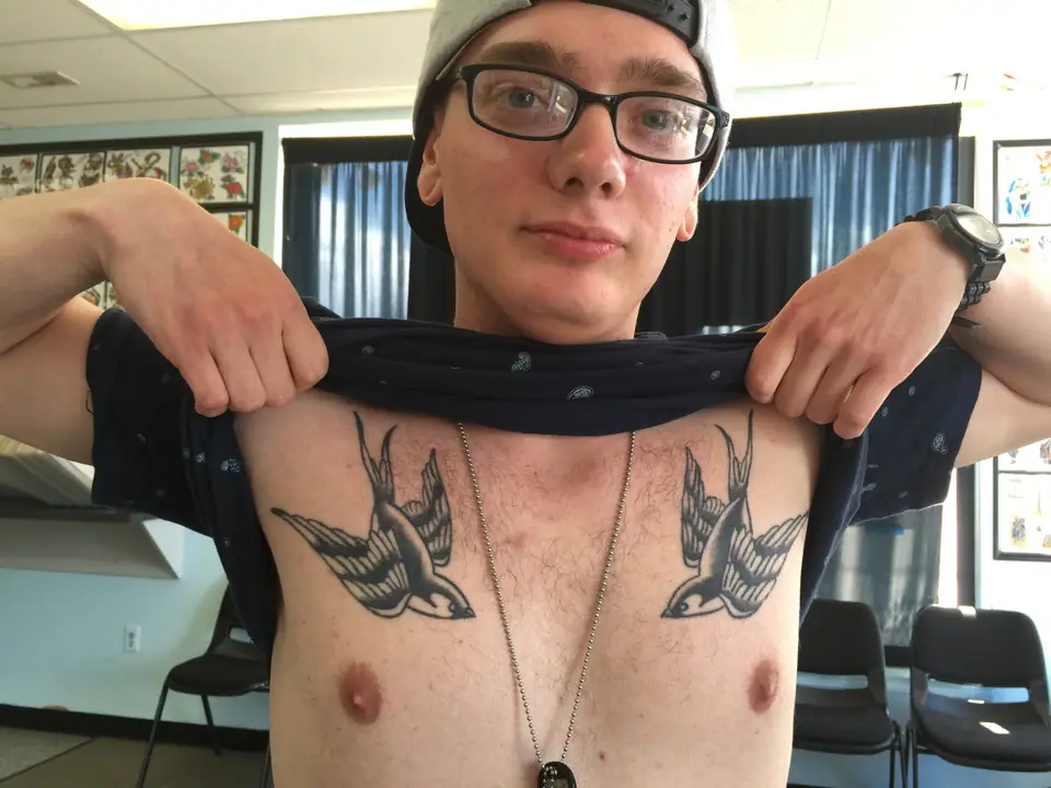Par de golondrinas tatuadas en el pecho, estilo tradicional