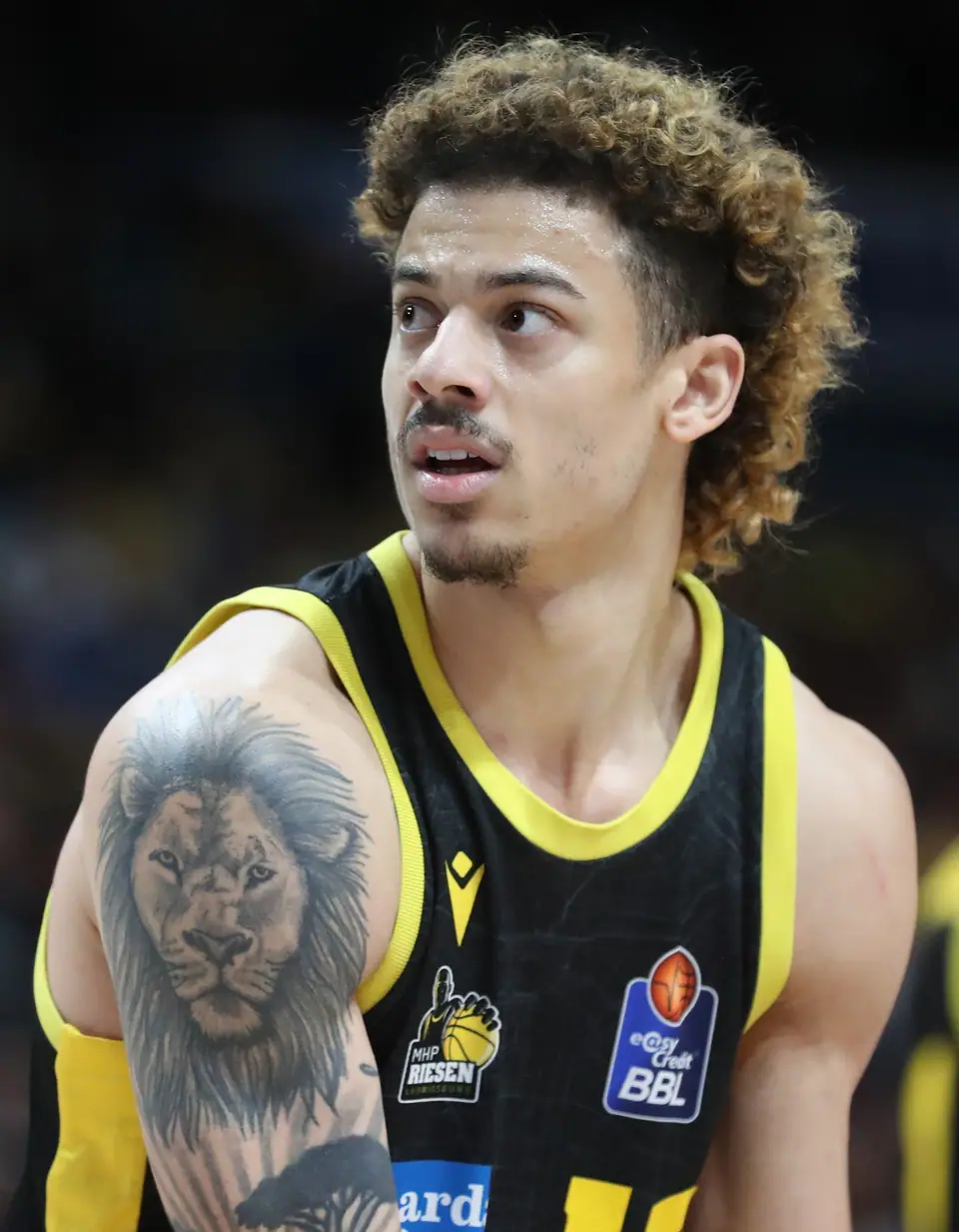 Tatuaje de león en el hombro de un jugador de básquet