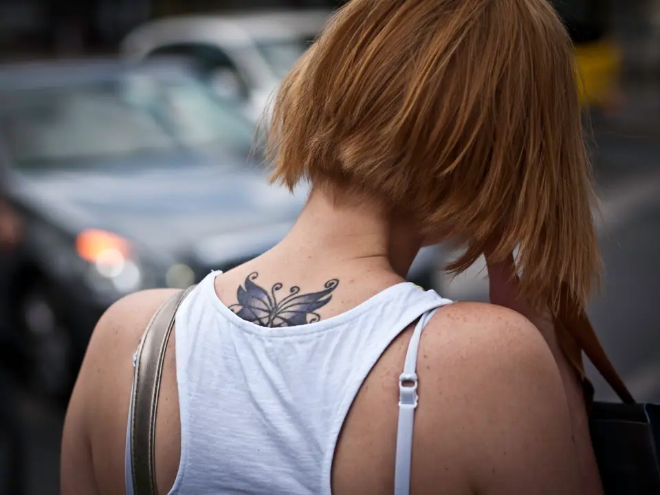 Tatuaje pequeño de mariposa en la espalda