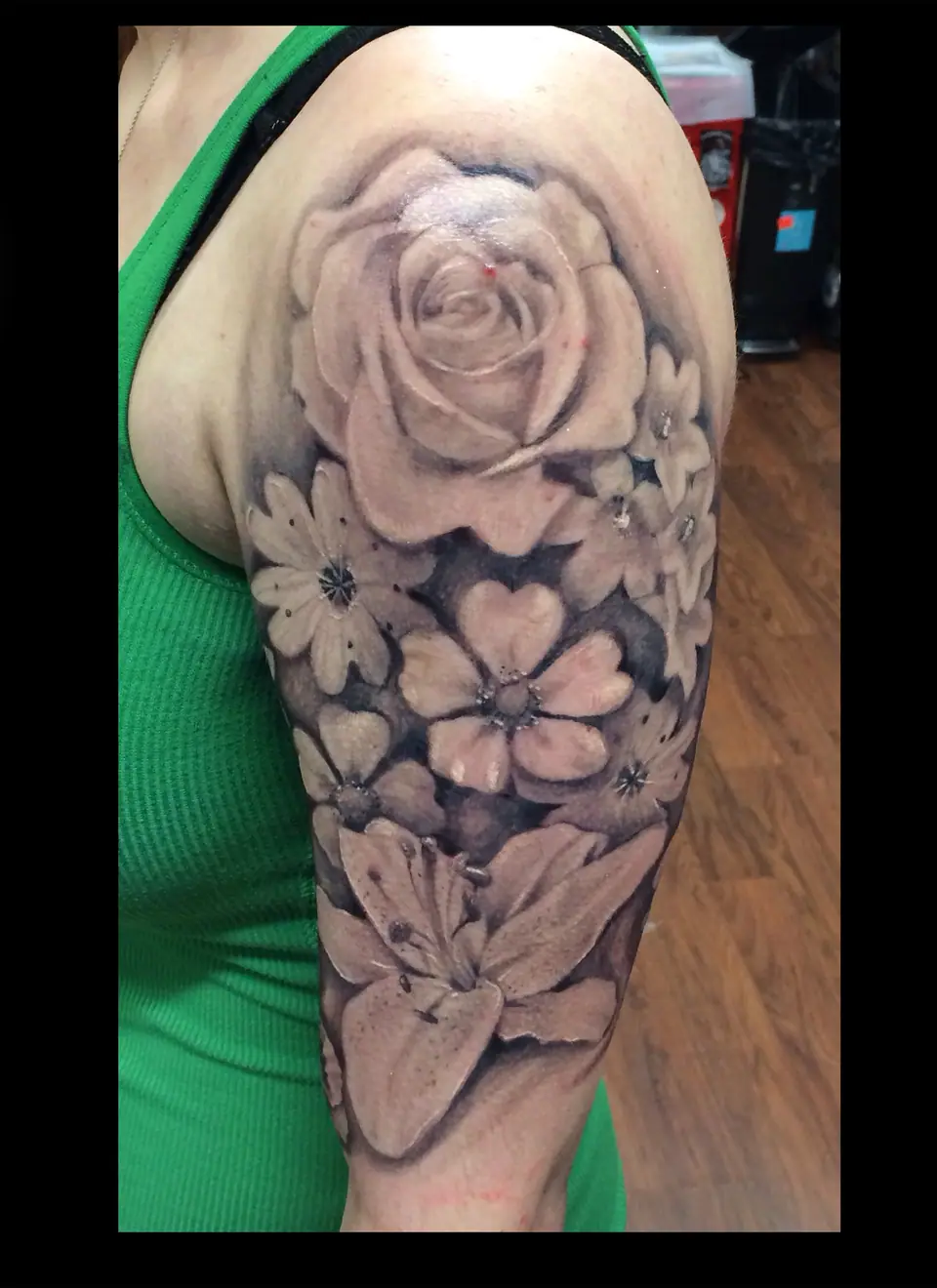 Tatuaje de rosas en blanco y negro en el hombro y brazo
